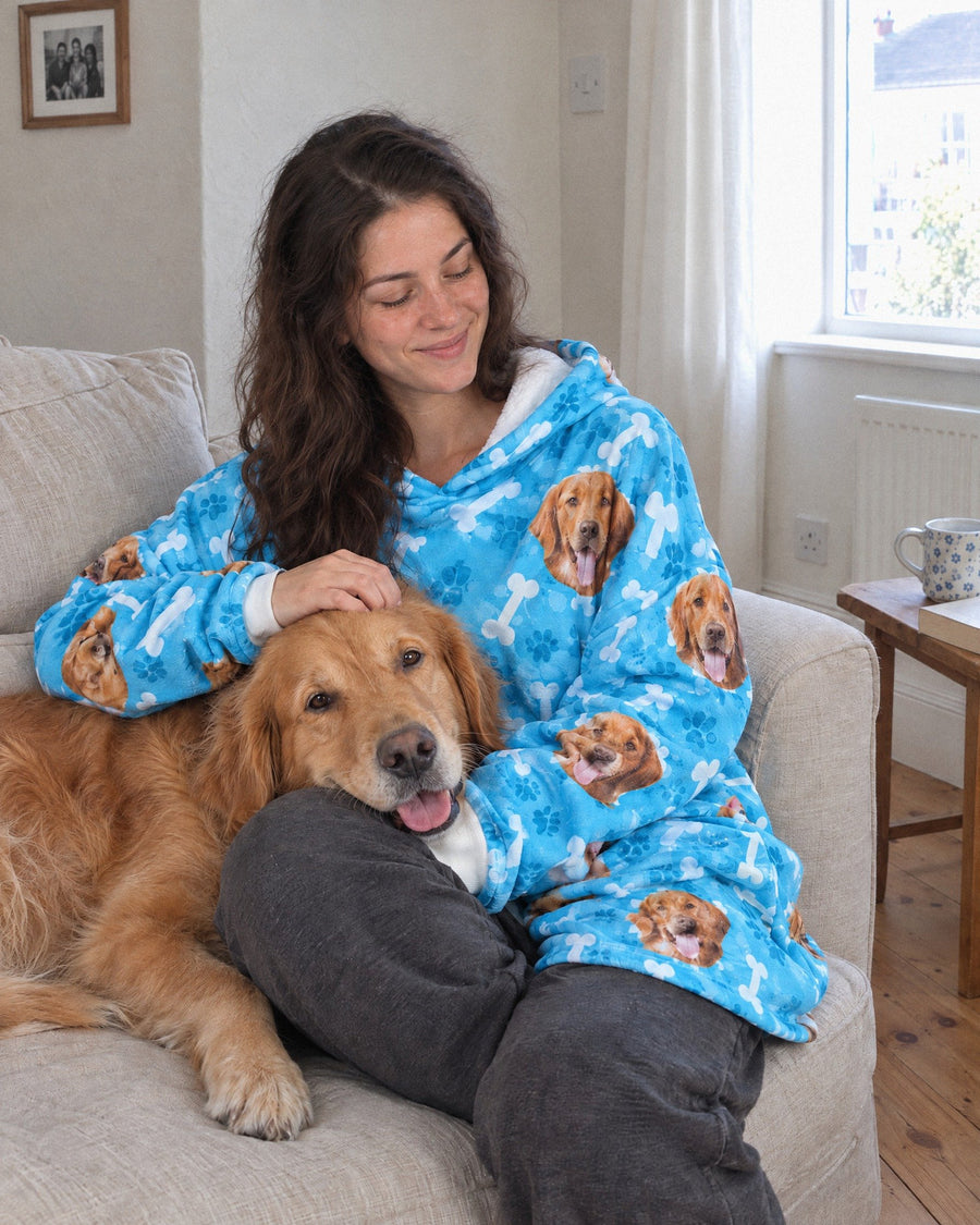 Woman on the sofa in a blue personalised dog hoodie with her golden retriever